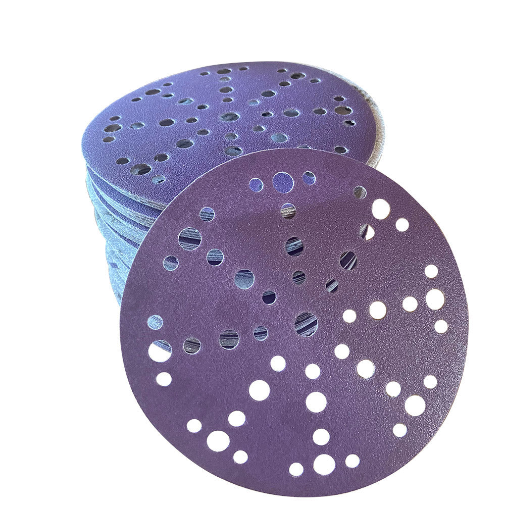 Stack of purple ceramic 6 inch multi-hole sanding discs with one disc face up