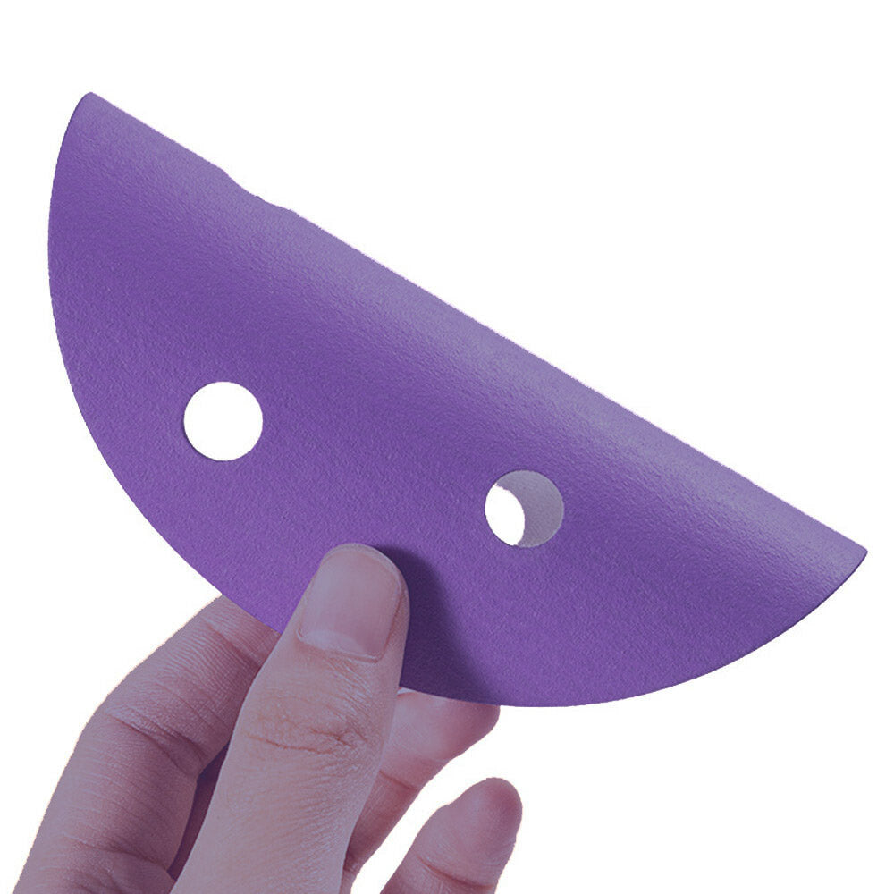 Purple ceramic sanding disc flexed by hand to show the flexible film backing