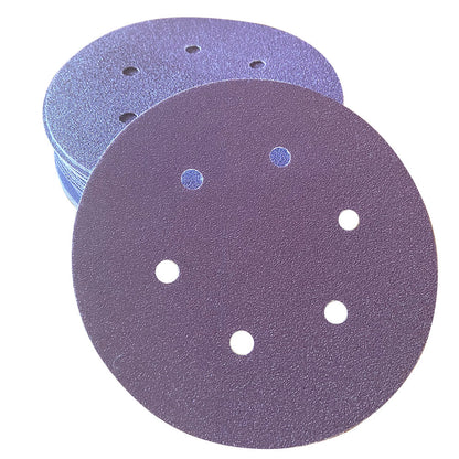 Stack of purple ceramic 6 inch 6-hole sanding discs with one disc face up showing the abrasive grain