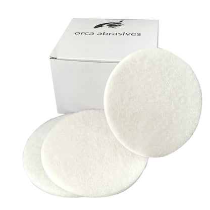 Two white non-scratch finishing pads beside an Orca Abrasives box